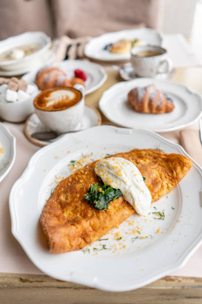 istock Breakfast. Frittata - italian omelet. Omelette with tomatoes, avocado, spinach and soft cheese. Croissants, coffee and other dishes on the table in the restaurant 1175227992