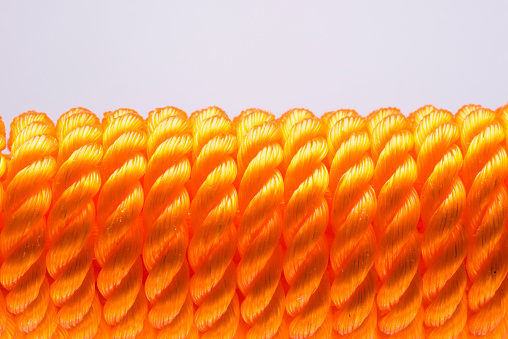 Closeup of orange nylon rope in white background