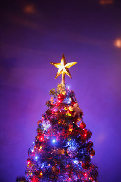 istock Christmas tree with festive star, purple background 1175236386