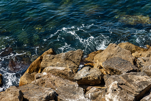 Close-up of a breakwater made of giant boulders, Mediterranean sea, in Liguria, Italy, Europe