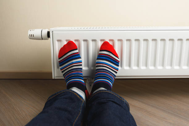istock legs with colorful socks in front of heating radiator 1175238798