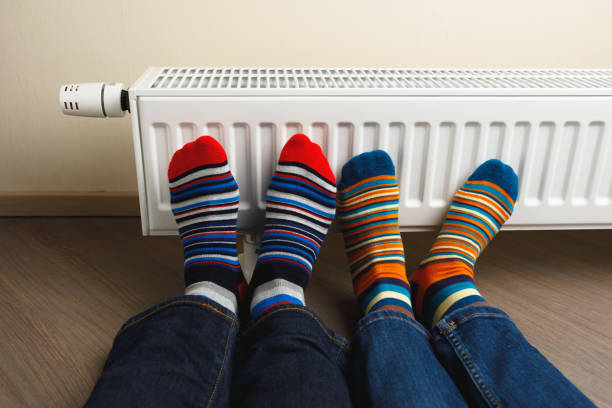 istock legs with colorful socks in front of heating radiator 1175241408