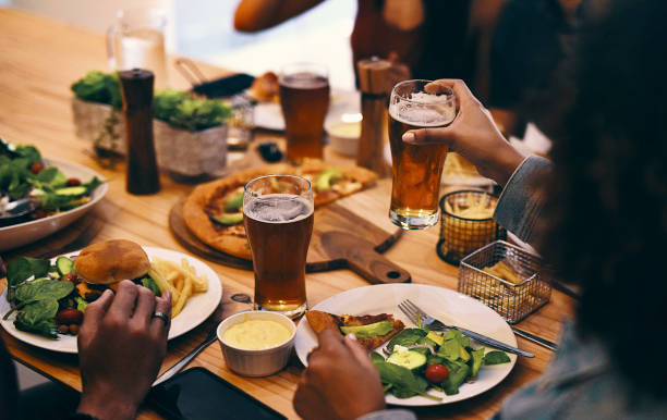 Cropped shot of a group of unrecognizable people enjoying food and drinks together