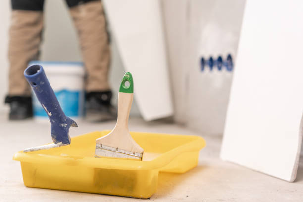 istock Paintbrush, roller and glue container on concrete surface. Composition tools for home repair and interior renovation indoors. 1175242855