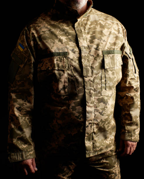 украинский солдат, одетый в форму, стоит в темноте - pants green camouflage men стоковые фото и изображения