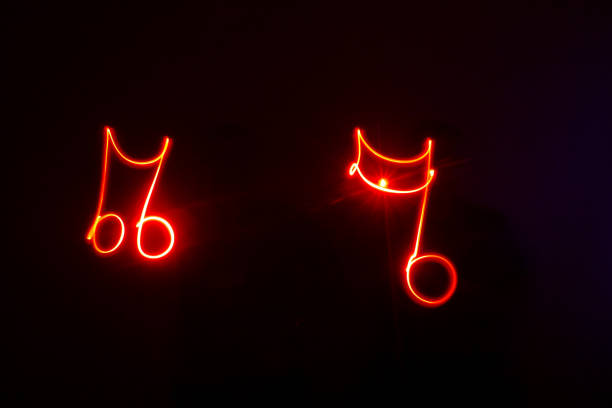 Music notes drawn with red neon lights Music notes drawn with red neon lights. studio shot with a black back ground. neon music notes stock pictures, royalty-free photos & images
