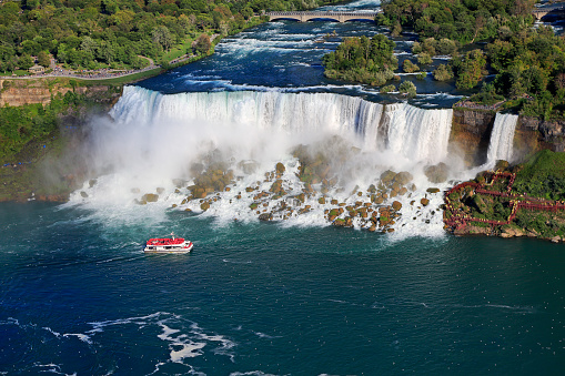 Aerial view of American and Bridal Veil Falls including Hornblower Boat sailing on Niagara River, Canada and USA natural border
