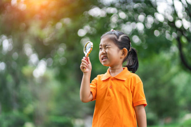 istock Girl uses magnifying glass discover and explore 1175243587