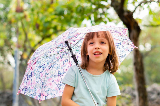 istock Child holding an umbrella outdoors. 1175246297