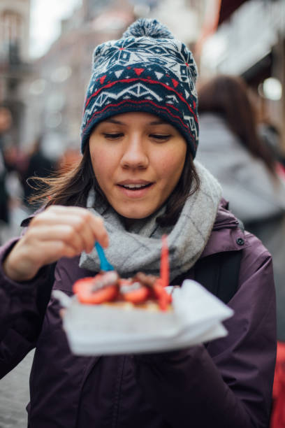 mujer con gofre belga al aire libre - brussels waffle belgian waffle people fotografías e imágenes de stock