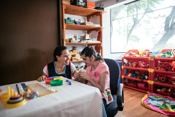 istock Hispanic teacher playing with woman with Down Syndrome 1175249431