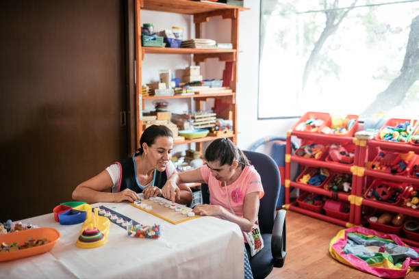 Hispanic teacher playing with woman with Down Syndrome
