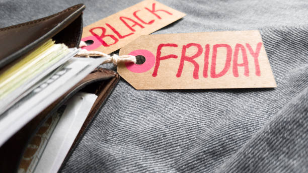 Brown wallet with money, dollars on a blue background, jeans texture, cardboard tag with red text cartera marrón con dinero, dólares sobre un fondo azul, textura de jeans, etiqueta de cartón con texto rojo black friday. black friday - día internacional de compras, promociones, descuentos, ventas. copiar espacio, lugar para texto, plano