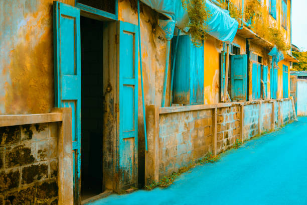 Old weathered House with yellow wall and brick and open green pastel window. architecture, classic home