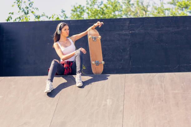istock sporty girl riding on longboard in park 1175252003