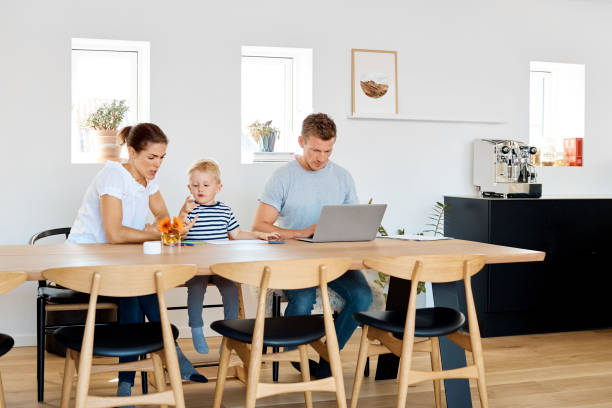 istock Woman and son sitting by man using laptop at table 1175252297