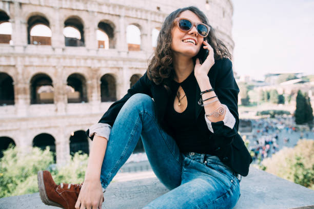 istock Woman talking on smart phone in front of Coliseum 1175252576