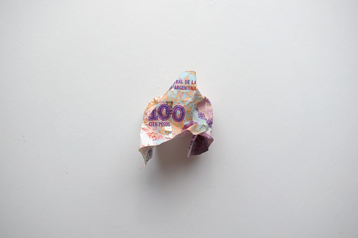 Devaluación de la moneda argentina. Crumpd, destroyed billete de cien pesos. photo