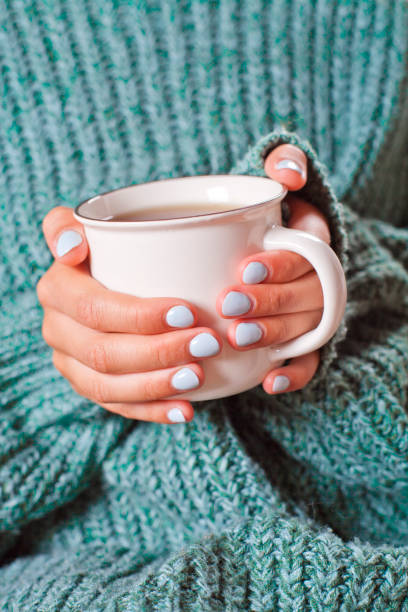 istock Female hands holding hot cup of coffee or tea. 1175259058