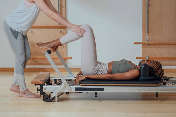 스포츠우먼 과 필라테스 운동 와 그녀의 트레이너 - pilates machine 뉴스 사진 이미지