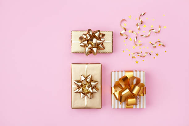 istock Golden gift or present boxes and star confetti on pink background top view. Festive composition for birthday, christmas or wedding. Flat lay. 1175262741