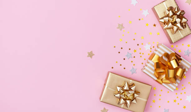 istock Golden gift or present boxes and star confetti on pink background top view. Festive composition for birthday, christmas or wedding. Flat lay. 1175262761