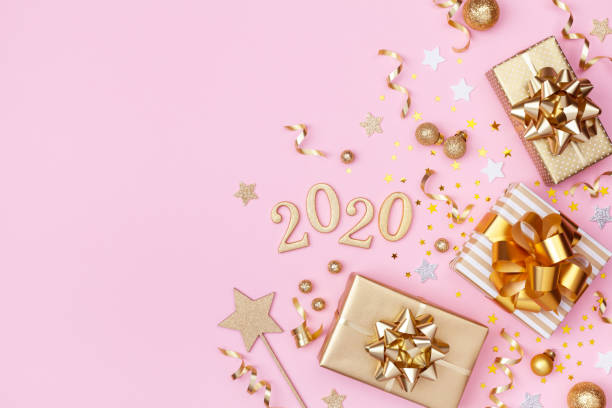 istock Golden gift or present boxes, 2020 numbers and Christmas decorations on pink background top view. Flat lay. 1175262775