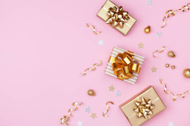 istock Golden gift or present boxes and Christmas decorations on pink background top view. Flat lay. 1175262788