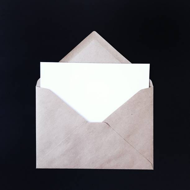 istock Blank postcard and craft envelope on black background. Mock up for greeting cards, stationery, postcards, prints, flyers, invitations, designs, letterhead. Isolated note card photography mockup. 1175263053