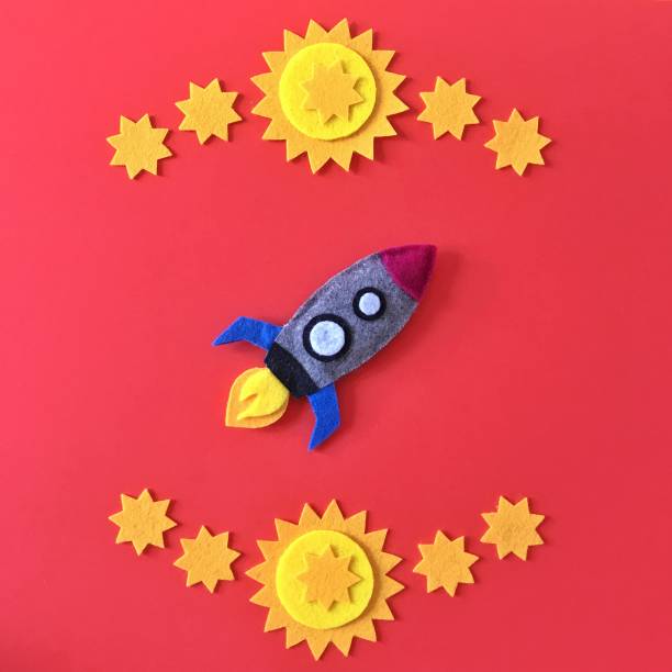istock Colorful handmade rocket ship crafted with felt fabric. Yellow stars on red background with rocketship toy to DIY. Crafting supplies for hand made baby crib mobile for nursery. Happy colorful image. 1175263127