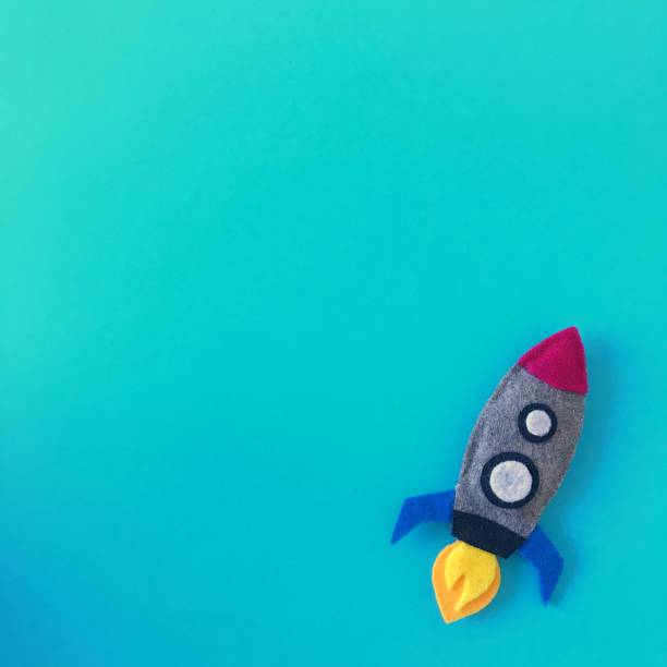 istock Blue background with small rocket toy hand made from felt fabric. Colorful handmade toy flat lay. Colorful crafting supplies space ship top view photography from above with copy space, text area. 1175263225