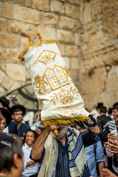 Holding up Torah Scroll at the Western Wall JERUSALEM - Oct 19 2016: Jewish man dancing with Torah scroll for Simchat Torah holiday, Kotel/Western or Wailing Wall simchat torah photos stock pictures, royalty-free photos & images