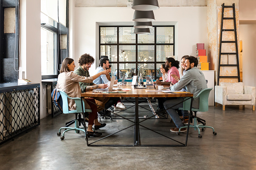 Group of young businesspeople working together at meeting office.