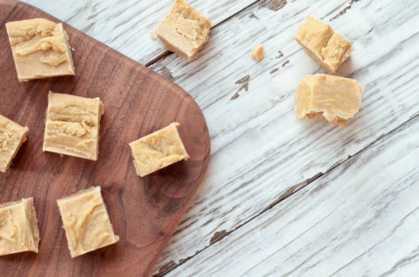 Delicious Homemade Peanut Butter Fudge Cut into Squares Squares of delicious, homemade peanut butter fudge over a rustic wood table background. Image shot from top view. fudge stock pictures, royalty-free photos & images