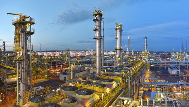 raffineria - fabbrica chimica di notte con edifici, condotte e illuminazione - impianto industriale - petrochemical plant oil refinery factory outdoors foto e immagini stock