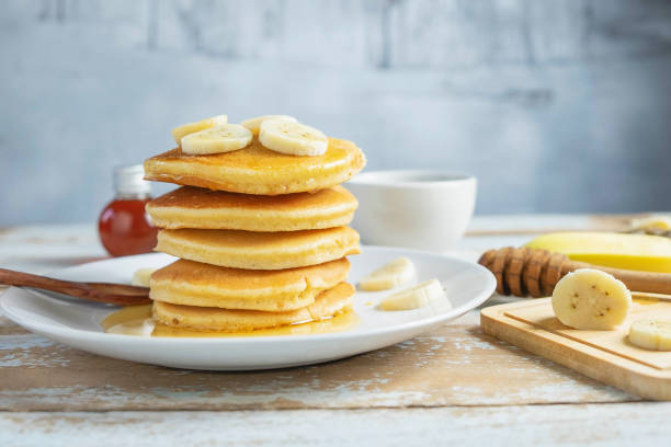 frittelle condite con miele e banane sul tavolo - honey caramel syrup fruit foto e immagini stock