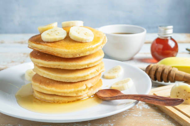 istock Pancakes topped with honey and bananas on the table 1175267142