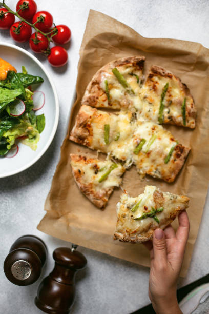 istock Flat lay with pizza, salad, tomato, salt and pepper on concrete table. 1175268819