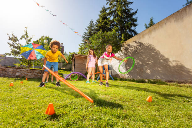 istock Group of kids play game throwing hula rings 1175269677