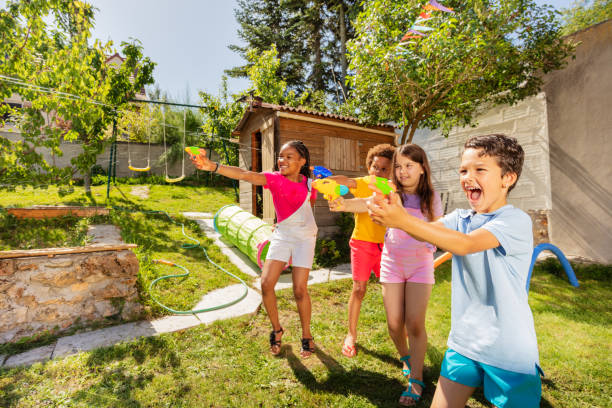 kids play water gun fight in a team with friends - toy gun imagens e fotografias de stock