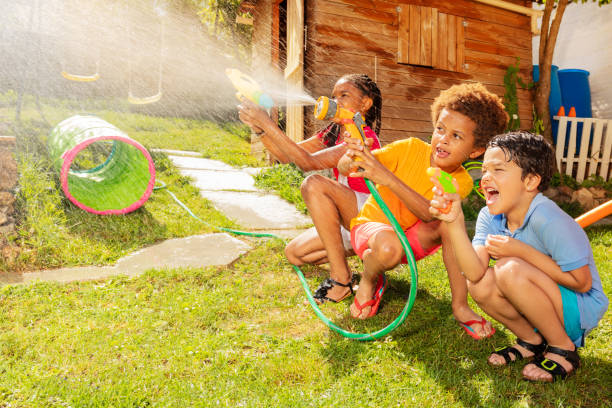 istock Kids hide and shoot with water guns in fun game 1175269723