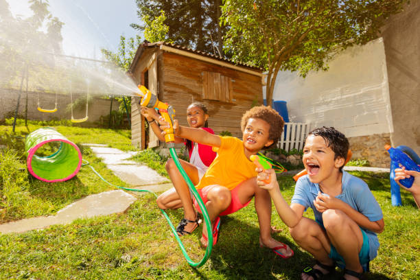 istock Fun with water guns and garden hose sprinkler 1175269736