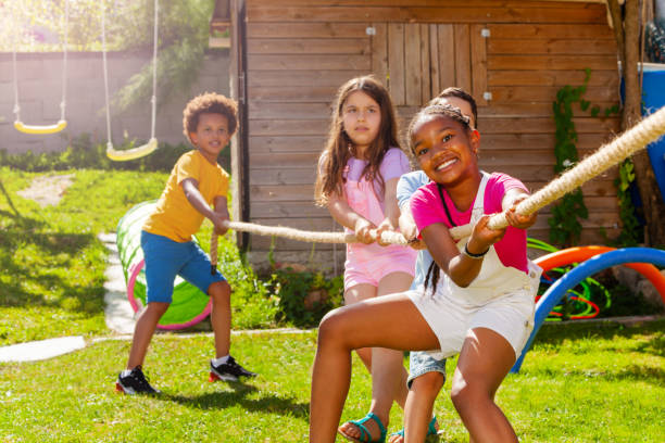 istock Group of diverse children pull rope in competition 1175269909