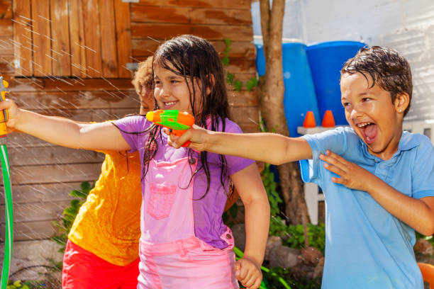istock Kids have fun shooting water gun in group game 1175269913