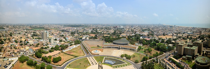 Lomé, Togo: cityscape of the Togolese capital - skyline seen from above the main square (Place de l'Independance) and the government area, with the Atlantic Ocean on the top right