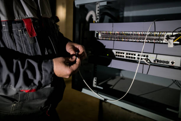 istock The technician attaching fiber optic on the Optical Distribution Frame. Man working in network server room with fiber optic hub for digital communications and internet. 1175275340