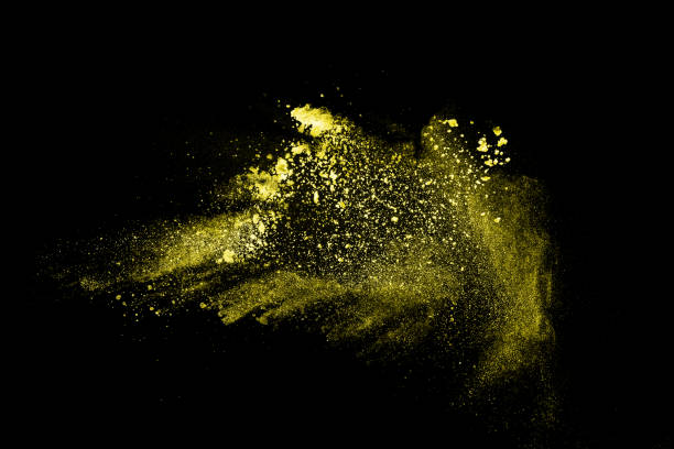 istock Yellow dust particles explosion on black background. Yellow powder  splash. 1175279154