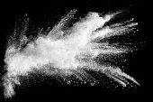 White powder explosion clouds.Freeze motion of white dust particles on black background.