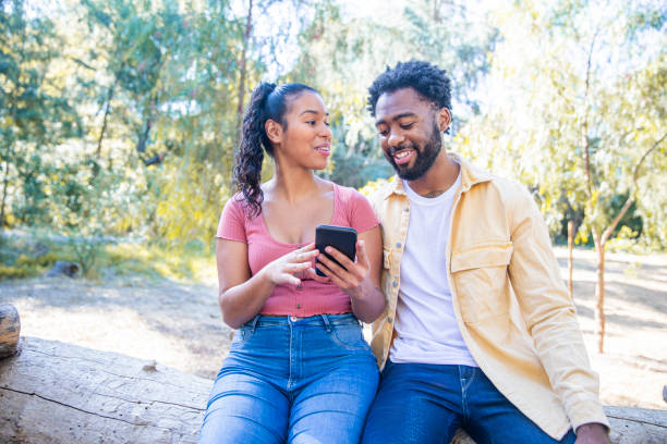 istock Young Diverse Couple Looking at Smartphone 1175280190