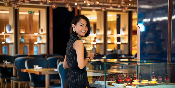 Asian Businesswoman ordering dinner in luxury restaurant Asian woman checking out of restaurant menu, ordering food exclusive dinner stock pictures, royalty-free photos & images